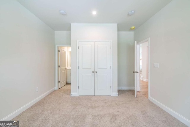 unfurnished bedroom featuring light carpet