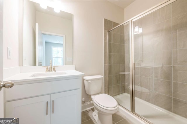 bathroom with vanity, toilet, an enclosed shower, and tile patterned flooring