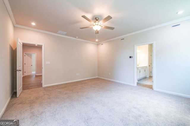 unfurnished bedroom featuring crown molding, light carpet, ensuite bathroom, and ceiling fan