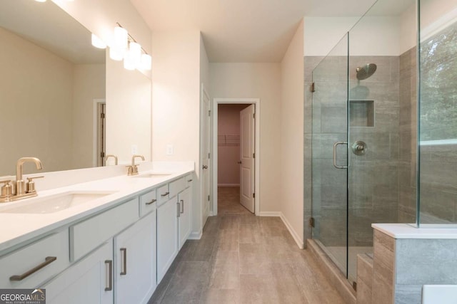 bathroom featuring a shower with shower door and vanity