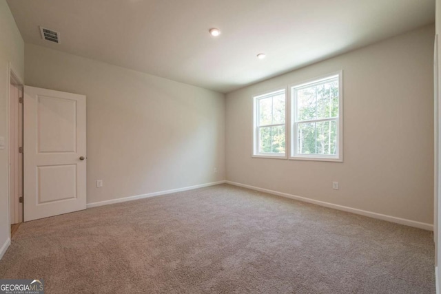 unfurnished room featuring light carpet