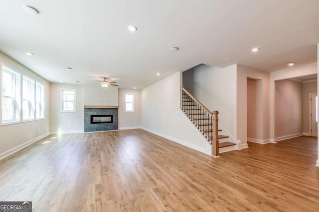 unfurnished living room with ceiling fan and light hardwood / wood-style flooring