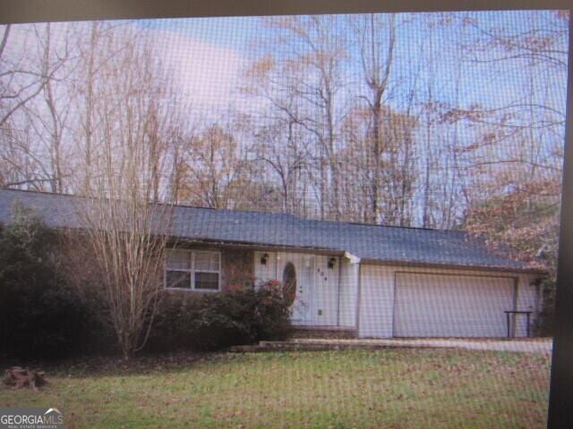 single story home with a garage and a front lawn