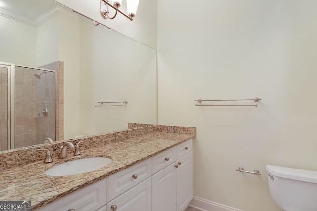 bathroom featuring ornamental molding, toilet, an enclosed shower, and vanity