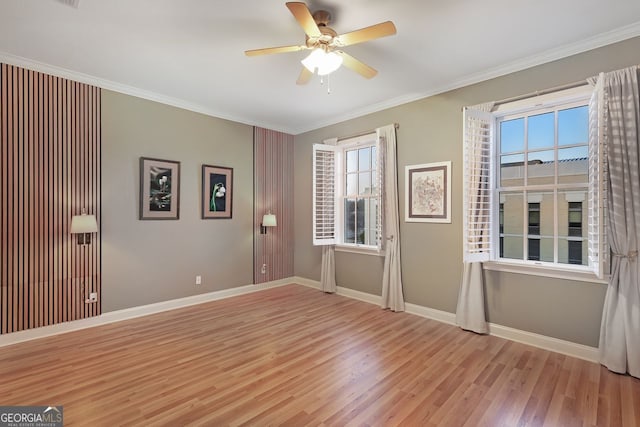 empty room featuring ceiling fan, ornamental molding, and light wood-type flooring