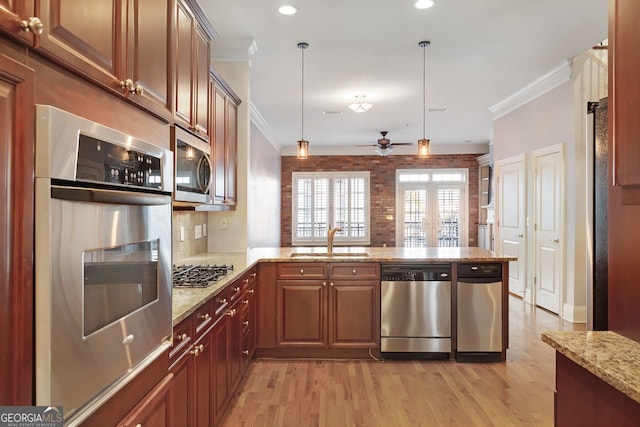 kitchen with sink, crown molding, stainless steel appliances, decorative light fixtures, and kitchen peninsula