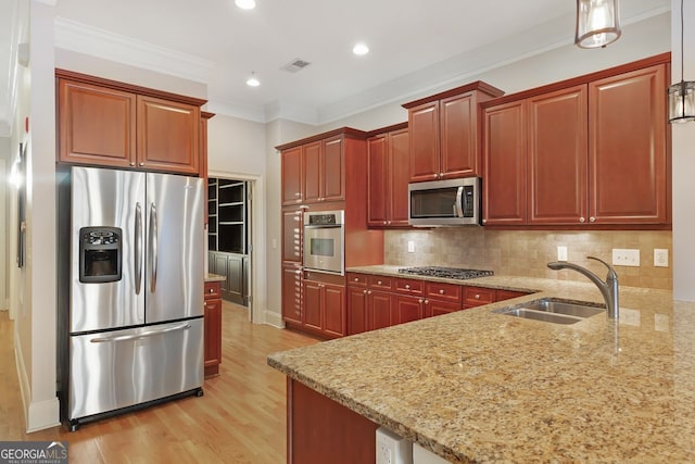 kitchen featuring tasteful backsplash, sink, hanging light fixtures, stainless steel appliances, and crown molding