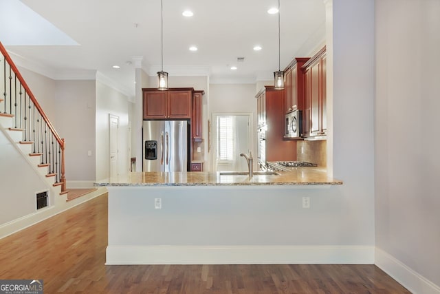 kitchen featuring hanging light fixtures, appliances with stainless steel finishes, sink, and kitchen peninsula