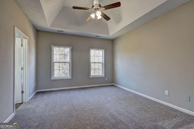 unfurnished room featuring ceiling fan, a textured ceiling, carpet floors, and a tray ceiling