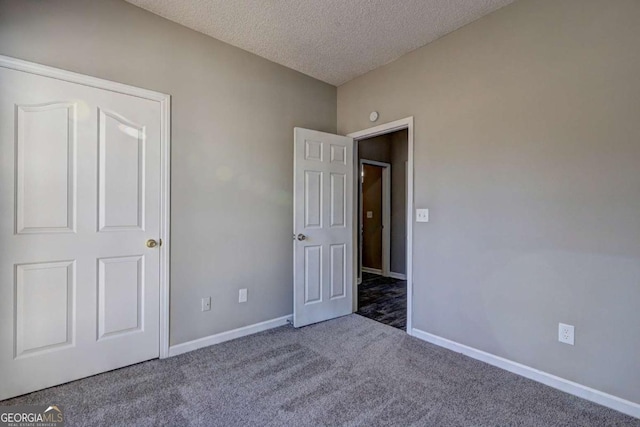 unfurnished bedroom featuring a textured ceiling and carpet flooring