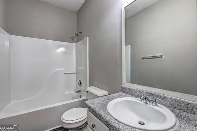 full bathroom featuring vanity, toilet, tub / shower combination, and a textured ceiling