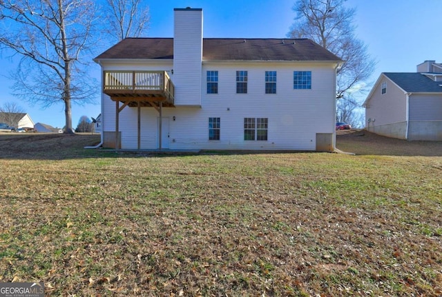 rear view of property featuring a lawn and a deck