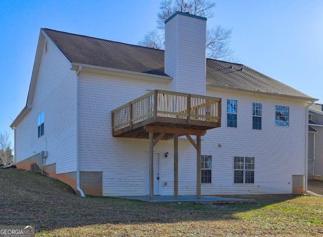 rear view of property featuring a yard and a deck