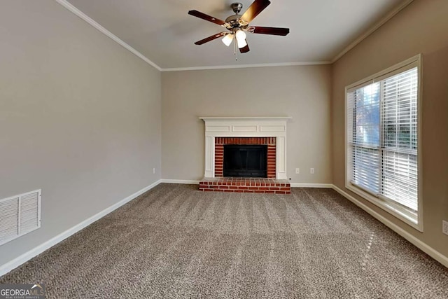 unfurnished living room with ceiling fan, a brick fireplace, ornamental molding, and carpet floors