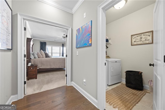 interior space featuring ceiling fan, washer and clothes dryer, crown molding, and hardwood / wood-style floors