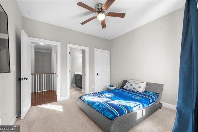 bedroom with carpet flooring, connected bathroom, and ceiling fan