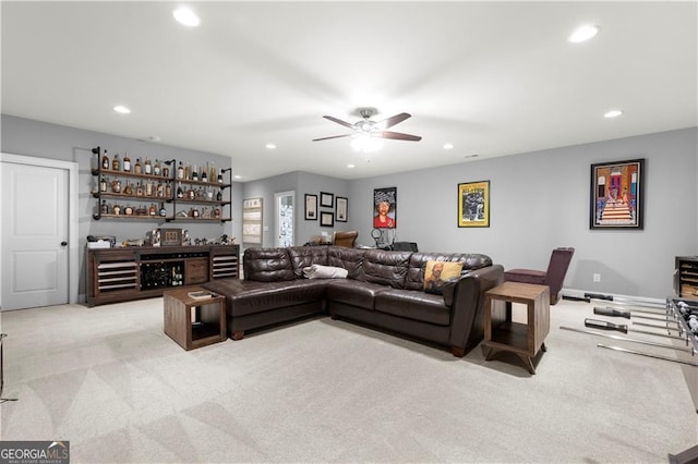 living room with ceiling fan, bar area, and light carpet