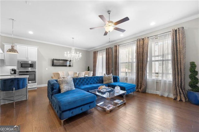 living room featuring ceiling fan with notable chandelier, ornamental molding, and dark wood-type flooring