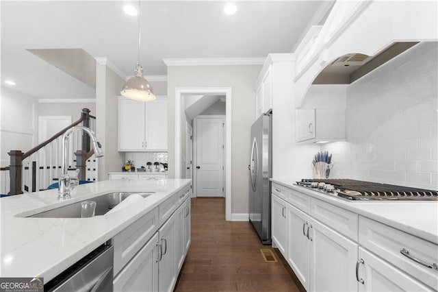 kitchen featuring dark hardwood / wood-style flooring, sink, decorative light fixtures, white cabinets, and appliances with stainless steel finishes