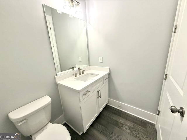 bathroom with vanity, toilet, and hardwood / wood-style floors