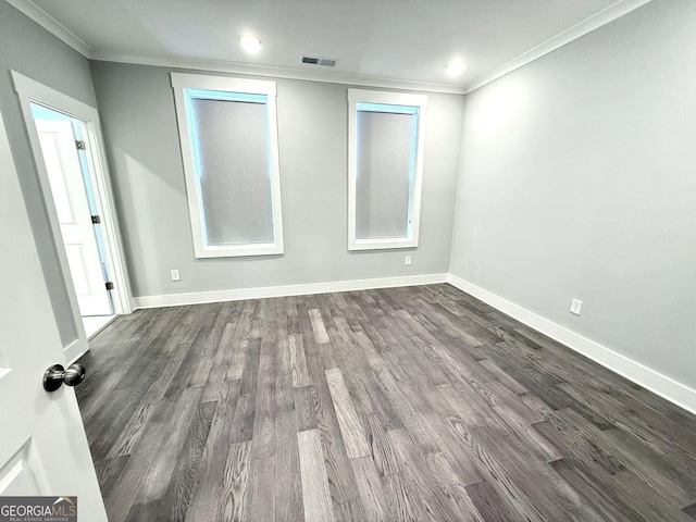 empty room with crown molding and dark hardwood / wood-style floors