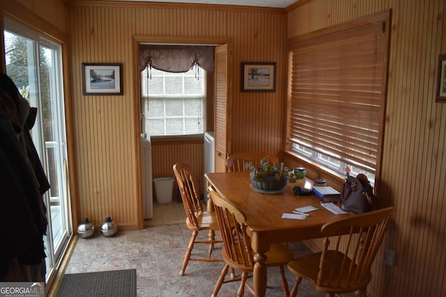 dining space featuring a wealth of natural light and wooden walls