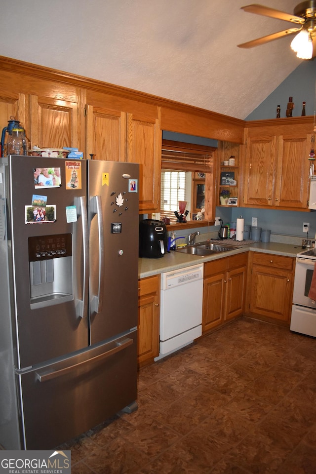 kitchen with sink, white appliances, vaulted ceiling, and ceiling fan