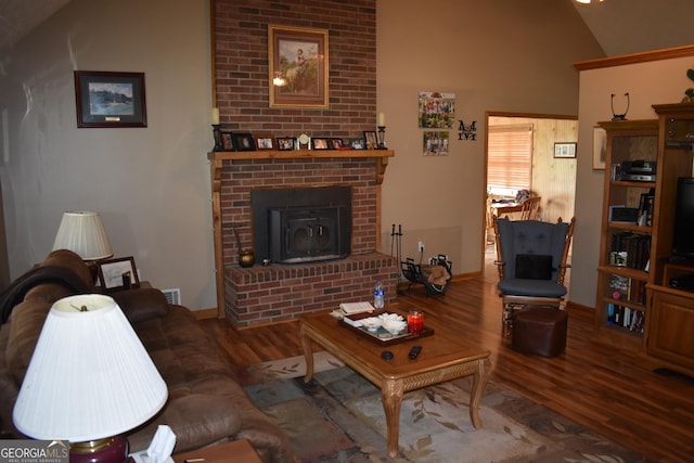 living room with a wood stove, hardwood / wood-style flooring, and lofted ceiling