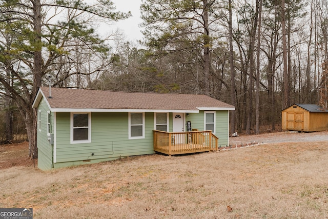 ranch-style home with a wooden deck, a storage shed, and a front lawn