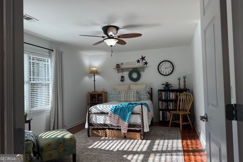 bedroom featuring multiple windows, dark hardwood / wood-style flooring, and ceiling fan