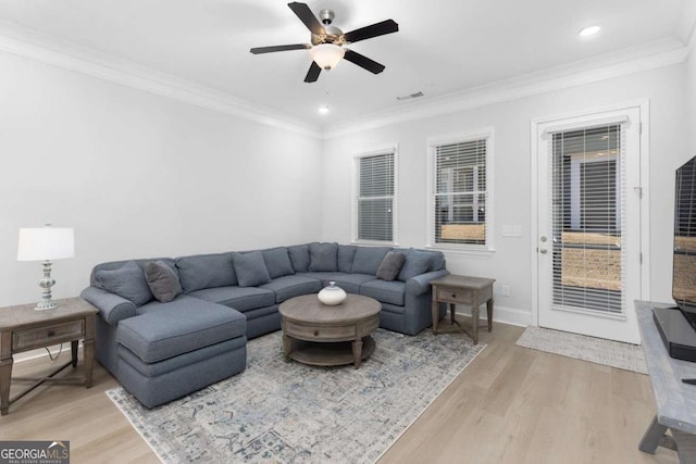 living room with ceiling fan, ornamental molding, and light hardwood / wood-style floors