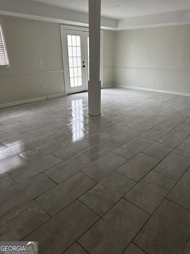 unfurnished room with a wainscoted wall