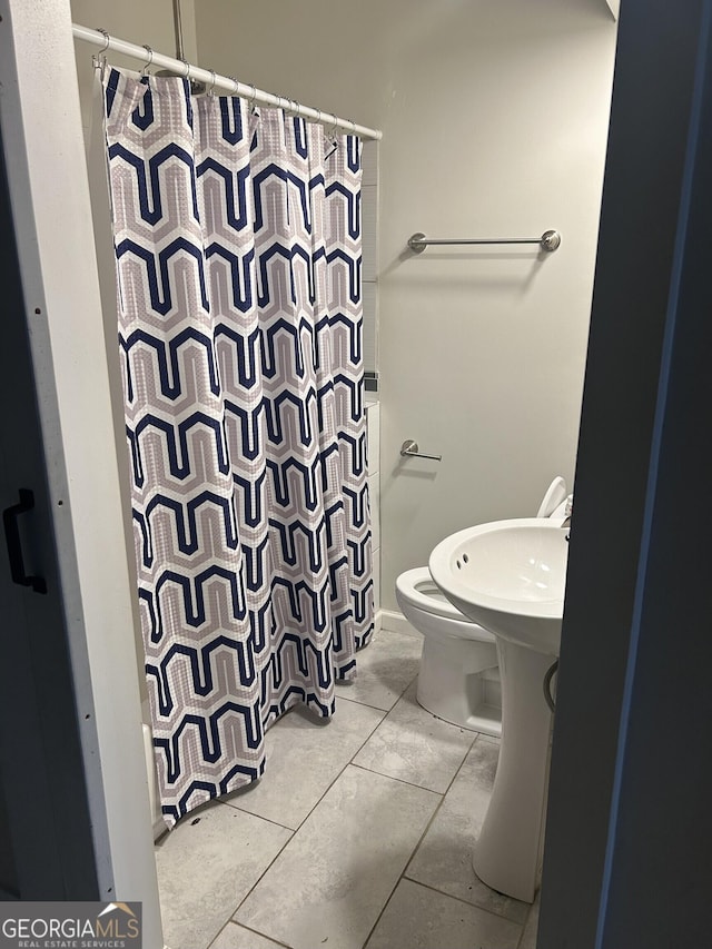 bathroom with tile patterned flooring, curtained shower, and toilet