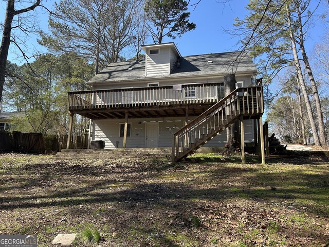 rear view of property featuring a deck and stairway