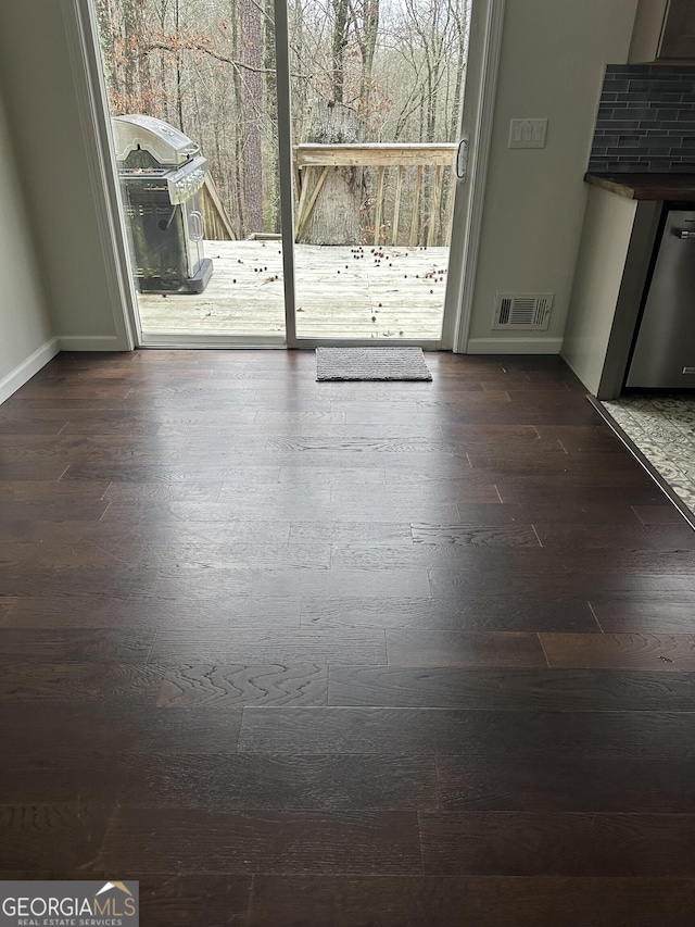 interior space featuring dark wood finished floors, visible vents, and baseboards