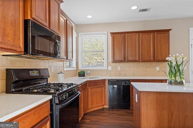 kitchen with sink, decorative backsplash, dark wood-type flooring, and black appliances