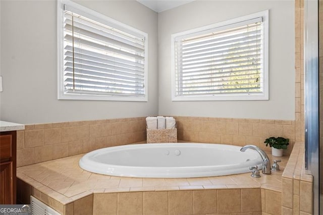 bathroom with vanity and a relaxing tiled tub