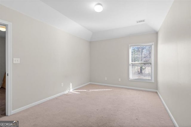 carpeted spare room featuring lofted ceiling