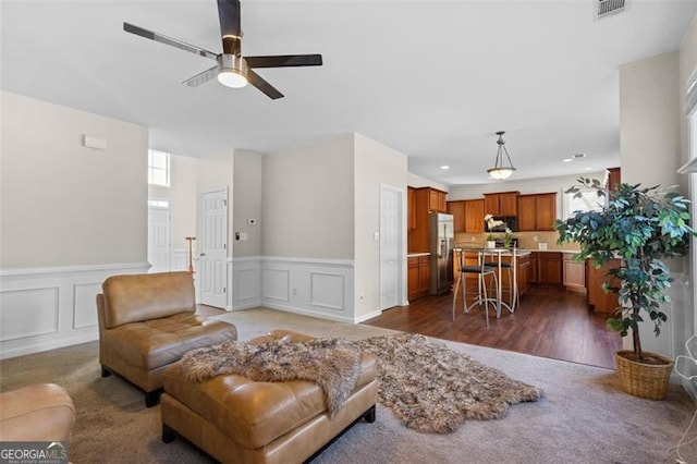 living room with dark wood-type flooring and ceiling fan