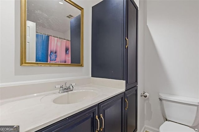 bathroom featuring toilet, a shower with shower curtain, and vanity