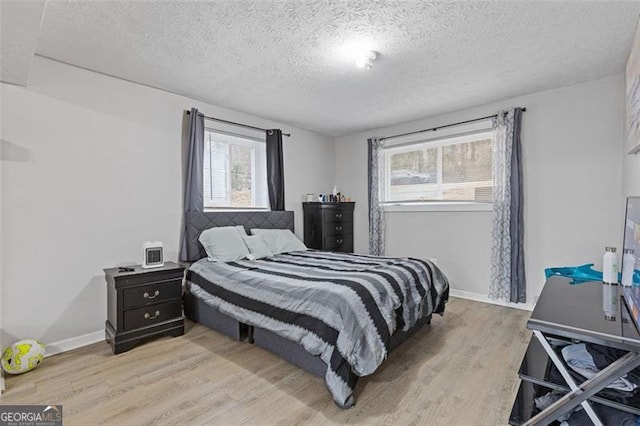 bedroom featuring a textured ceiling and light hardwood / wood-style flooring