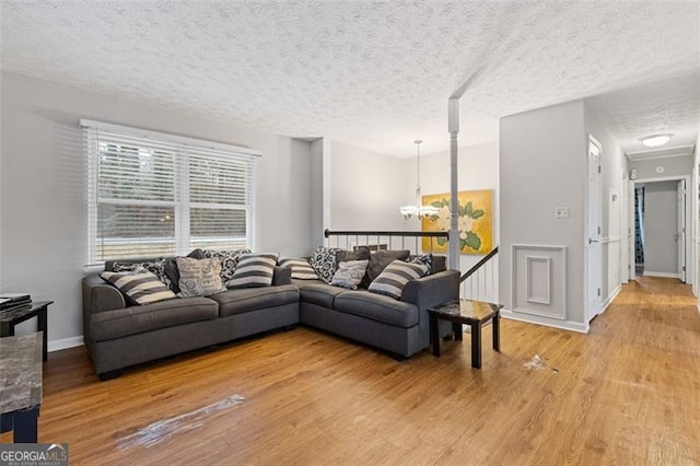 living room featuring a notable chandelier, a textured ceiling, and wood-type flooring