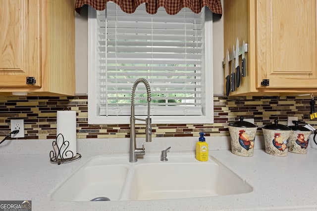 room details featuring light brown cabinetry, sink, light stone countertops, and tasteful backsplash