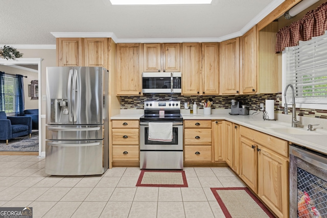 kitchen featuring sink, light tile patterned flooring, ornamental molding, beverage cooler, and stainless steel appliances