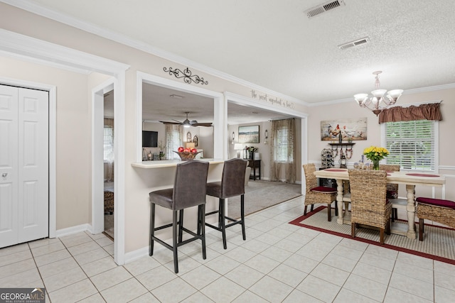 tiled dining room with crown molding, ceiling fan with notable chandelier, and a textured ceiling