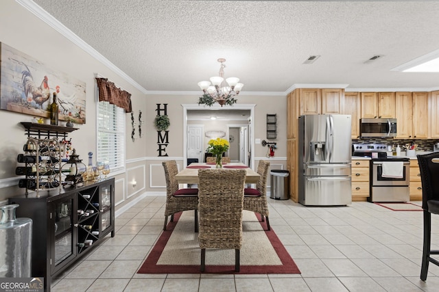 tiled dining space with a textured ceiling, crown molding, and an inviting chandelier