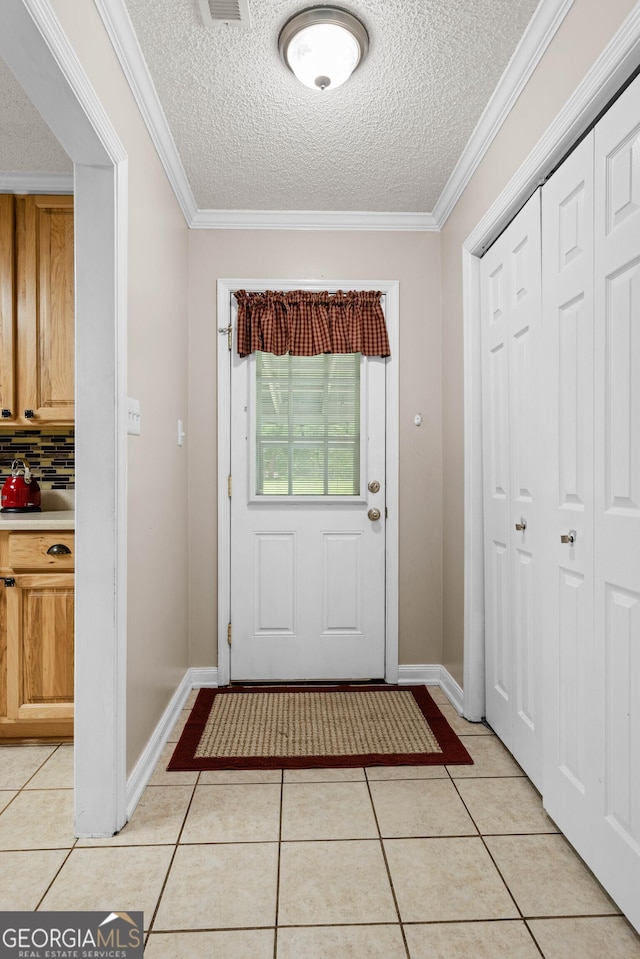 doorway to outside featuring ornamental molding, light tile patterned floors, and a textured ceiling