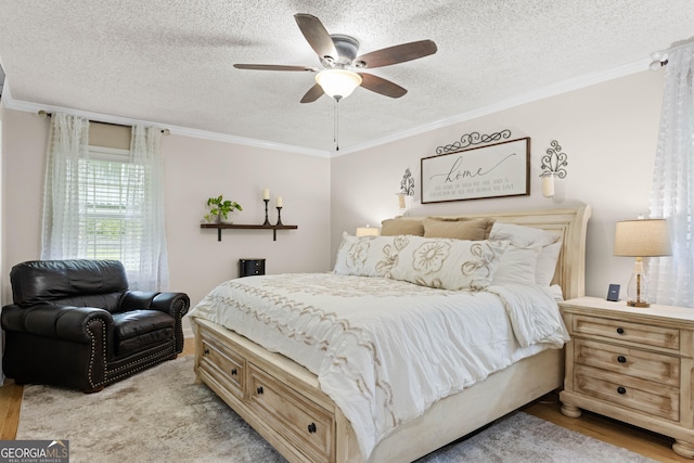 bedroom featuring ceiling fan, ornamental molding, light hardwood / wood-style floors, and a textured ceiling