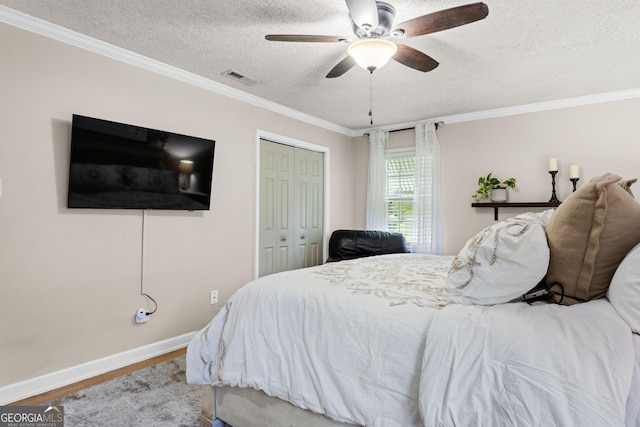 bedroom featuring a closet, ceiling fan, crown molding, and a textured ceiling