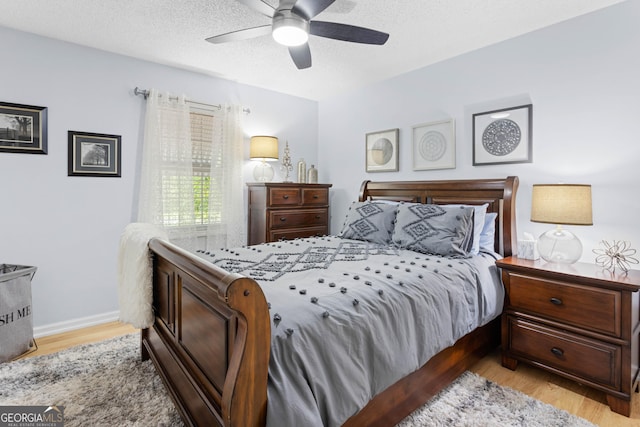 bedroom featuring ceiling fan, a textured ceiling, and light hardwood / wood-style flooring